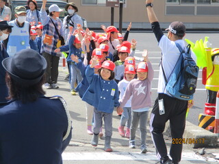 子どもたちが手を挙げて横断歩道を渡っています