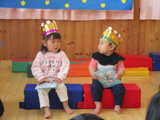 子どもたちが王冠をかぶって見つめあっています