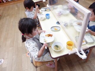 正しく食器を置き、背筋を伸ばして給食を食べる子どもたち