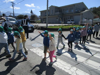 年長さんが横断歩道を手を挙げてわたっています