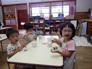 ３歳児がチョコバナナを食べ、チョコが顔についています