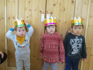 未満児クラスの１月生まれの子どもが冠をかぶっています