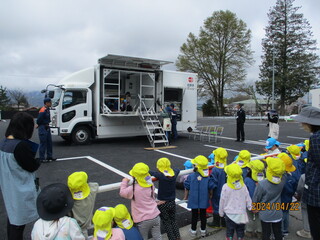 地震体験車を子どもたちが見学しています