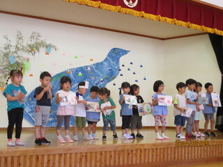 子どもたちがステージにあがり、誕生カードをみせています