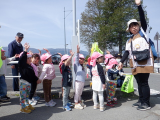 3歳児が手を挙げて横断歩道を渡っています