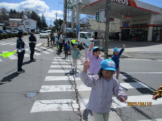 5歳児が信号機の横断歩道を手を挙げて渡っています