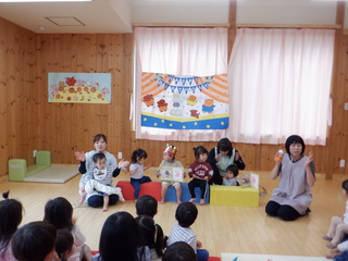 誕生児がみんなの前に座っています