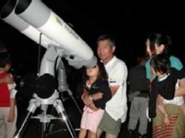 望遠鏡で星空を観察する親子